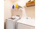 Functional laundry room with white washer and dryer, and ample shelving for storage at 4823 Coral Castle Dr, Kissimmee, FL 34746