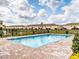 Sparkling community pool featuring brick paver surround, black metal safety fence and residential buildings nearby at 4823 Coral Castle Dr, Kissimmee, FL 34746