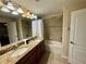 Bathroom featuring double sinks, granite countertops and a shower-tub combination at 4875 Clock Tower Dr, Kissimmee, FL 34746