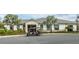 Community clubhouse with golf cart parked out front; enhanced by palms and architectural details at 4875 Clock Tower Dr, Kissimmee, FL 34746