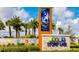 Story Lake community entrance sign with palm trees and colorful icons, under a sunny sky at 4875 Clock Tower Dr, Kissimmee, FL 34746