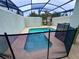 Private screened pool with a safety fence and lounge chair at 4875 Clock Tower Dr, Kissimmee, FL 34746