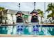 Close-up of themed drink containers poolside, with a pool and building in the background at 4875 Clock Tower Dr, Kissimmee, FL 34746