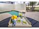 Private pool with lounge chair and a refreshing beverage setup on a tray table at 4875 Clock Tower Dr, Kissimmee, FL 34746