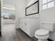 Bright bathroom featuring a white vanity with modern hardware, a large mirror, and vinyl flooring at 4919 Dunmore Ln, Kissimmee, FL 34746