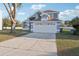 Two-story house with a two-car garage, driveway, and a well-manicured lawn at 4919 Dunmore Ln, Kissimmee, FL 34746