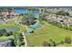 Aerial view of a dog park, playground, lake, and tennis courts in a community surrounded by lush landscaping at 507 Pamplona Pl, Davenport, FL 33837