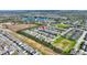 Aerial view of a community highlights its organized layout and the community's surrounding green spaces and a lake at 507 Pamplona Pl, Davenport, FL 33837