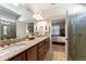 Bright bathroom featuring double sinks, granite countertops, and glass-enclosed shower at 507 Pamplona Pl, Davenport, FL 33837