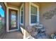 Welcoming front porch with decorative glass door, charming chairs and side table at 507 Pamplona Pl, Davenport, FL 33837