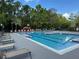 Community pool with lounge chairs, lush greenery, and a nearby playground at 5152 Conroy Rd # 1333, Orlando, FL 32811