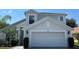 Two-story home featuring a two-car garage, neutral paint, and manicured landscaping at 525 Garberia Dr, Davenport, FL 33837