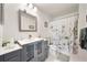 Well-lit bathroom featuring a modern vanity, framed mirror, and a shower-tub combination with a stylish curtain at 5463 Vineland Rd # 5107, Orlando, FL 32811