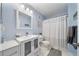 Well-maintained bathroom features a blue accent wall, a modern vanity, and a shower-tub combination at 5463 Vineland Rd # 5107, Orlando, FL 32811