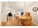 Open-concept dining area featuring wood floors, modern chandelier, and an adjacent kitchen and living area at 5463 Vineland Rd # 5107, Orlando, FL 32811