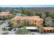 Aerial view of multi-Gathering home complex with a pond, fountain, mature trees, and covered parking at 5463 Vineland Rd # 5107, Orlando, FL 32811