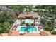 An aerial view shows the community pool and lounging area, surrounded by palm trees and lush landscaping at 5463 Vineland Rd # 5107, Orlando, FL 32811