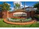 Entrance to Eagle Pointe features a brick sign, stone signage, flowers, and manicured plants at 563 Eagle Pointe S, Kissimmee, FL 34746