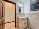 Bathroom featuring a vanity with a sink and decorative fixtures, and an open door at 6 Palm Way, Haines City, FL 33844