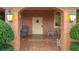 Welcoming front porch with brick flooring and seating area, framed by lush landscaping at 6 Palm Way, Haines City, FL 33844