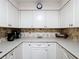 Kitchen with all white cabinetry and neutral backsplash at 6 Palm Way, Haines City, FL 33844