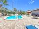 Backyard pool and patio area with mature palms, a brick-paved deck, and outdoor seating at 6 Palm Way, Haines City, FL 33844