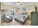 Comfortable bedroom with light green walls, hardwood floors, and a plush armchair at 651 Glendora Rd, Kissimmee, FL 34759