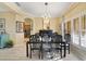 Dining room featuring hardwood floors, elegant chandelier, and a glass table set for eight at 651 Glendora Rd, Kissimmee, FL 34759