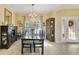 Dining room featuring hardwood floors, elegant chandelier, and a glass table set for eight at 651 Glendora Rd, Kissimmee, FL 34759