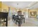 Dining room featuring hardwood floors, elegant chandelier, and a glass table set for eight at 651 Glendora Rd, Kissimmee, FL 34759