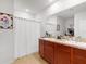 Bright bathroom with a double vanity, framed mirror, and white shower curtain at 758 Lafayette Ln, Haines City, FL 33844