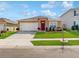 Charming single-story home with a well-manicured lawn, a two car garage, and a red front door at 758 Lafayette Ln, Haines City, FL 33844