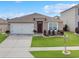 Charming single-story home with a well-manicured lawn, landscaped garden beds, and a two-car garage at 758 Lafayette Ln, Haines City, FL 33844