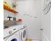 Bright laundry room featuring a washer, dryer, shelving, and decorative wall art at 758 Lafayette Ln, Haines City, FL 33844