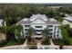 Aerial view showcases building's balconies, brick accents, and palm-lined facade at 7660 Whisper Way # 104, Reunion, FL 34747