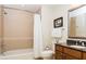 Bathroom featuring a shower-tub combo, a toilet, and vanity with drawers and framed mirror at 7660 Whisper Way # 104, Reunion, FL 34747