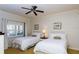 Cozy bedroom featuring two twin beds, a ceiling fan, and bright natural light from the window at 7660 Whisper Way # 104, Reunion, FL 34747