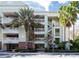 Three-story residential building featuring multi-level balconies and palm tree landscaping at 7660 Whisper Way # 104, Reunion, FL 34747