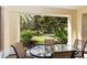 Covered patio with table and chairs overlooking lush greenery at 7660 Whisper Way # 104, Reunion, FL 34747