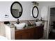 Bathroom featuring dual vanities, vessel sinks, framed mirrors, and granite counters at 7670 Milano Dr, Orlando, FL 32835