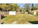 Spacious backyard featuring a storage shed and mature trees along a wooden fence at 7904 Empire Ave, Orlando, FL 32810