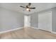 Bright bedroom features light gray walls, wood-look floors, ceiling fan, and closet with white paneled doors at 7904 Empire Ave, Orlando, FL 32810