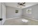 Bedroom with light gray walls, wood-look tile flooring, and two windows providing natural light at 7904 Empire Ave, Orlando, FL 32810