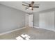 Bright bedroom features light gray walls, tile floor, ceiling fan, and closet with white paneled doors at 7904 Empire Ave, Orlando, FL 32810