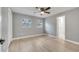 Bedroom with light gray walls, wood-look flooring, two windows providing natural light, and a ceiling fan at 7904 Empire Ave, Orlando, FL 32810