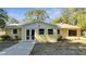 Charming yellow single-story home featuring a concrete walkway, white trim, and well-maintained landscaping at 7904 Empire Ave, Orlando, FL 32810