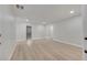 Spacious living room with light wood-look floors, neutral paint, and a view of the hallway and adjacent rooms at 7904 Empire Ave, Orlando, FL 32810