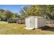 A white, corrugated metal, backyard storage shed near a wooden fence at 7904 Empire Ave, Orlando, FL 32810