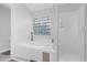 Bright bathroom featuring a soaking tub with glass block window and separate glass-enclosed shower at 816 Garden Glen Loop, Lake Mary, FL 32746