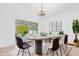 Bright dining room featuring a large table, modern chandelier, contemporary art, and seamless access to outdoor patio at 816 Garden Glen Loop, Lake Mary, FL 32746